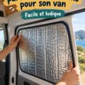 Un pare-soleil occultant installé dans un van aménagé, offrant une intimité aux occupants.